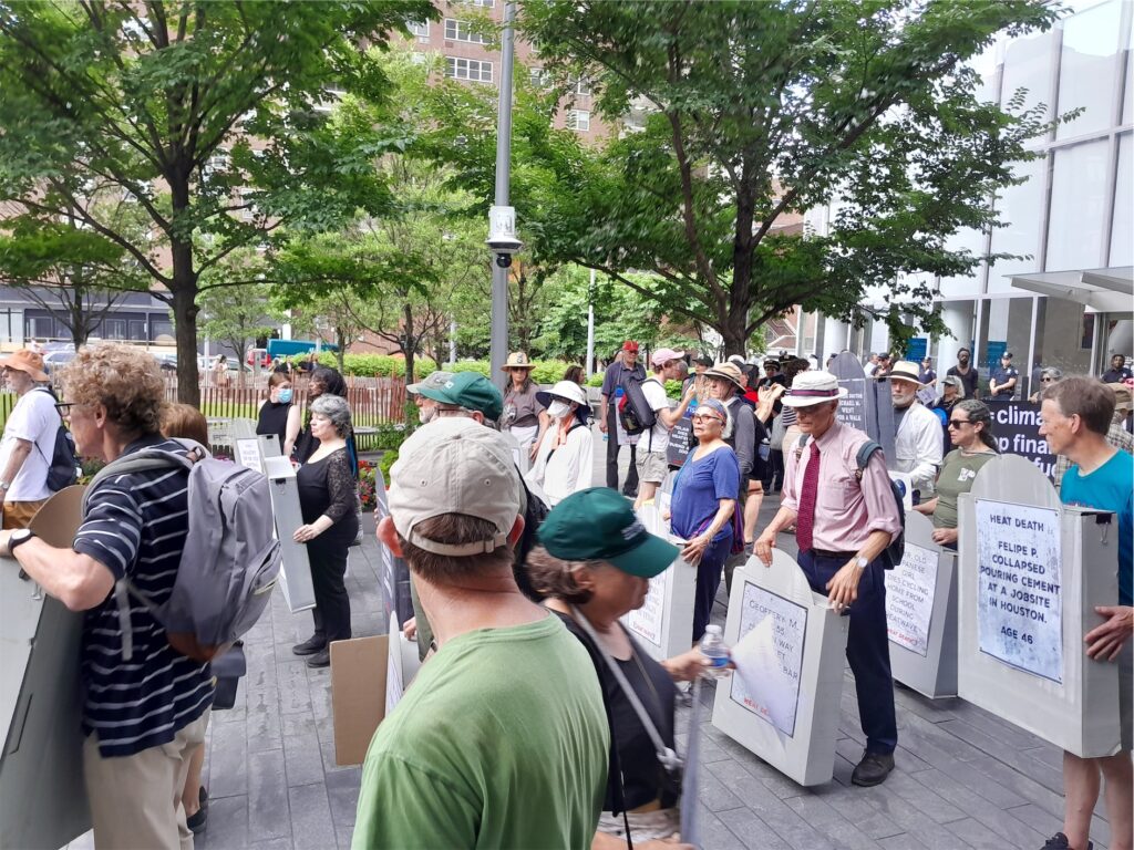Activists with cardboard gravestones and other signs stand in rows outside Citigroup headquarters entrance during the rally before the civil disobedience action.
