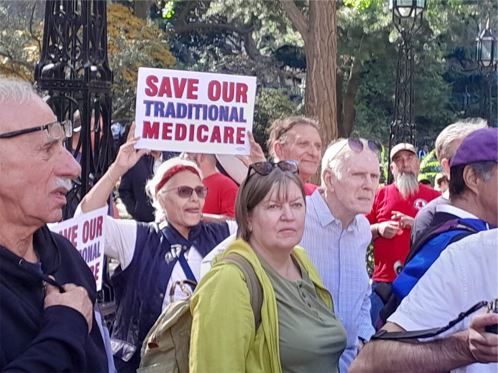 Retired NYC employees and allies at a rally outside City Hall. Sign reads Save Our Traditional Medicare.