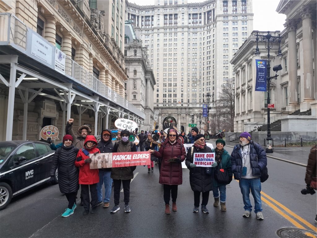 RE members marching with signs reading “Radical Elders”, “Save Our Traditional Medicare”, and “WE are all ONE.”
