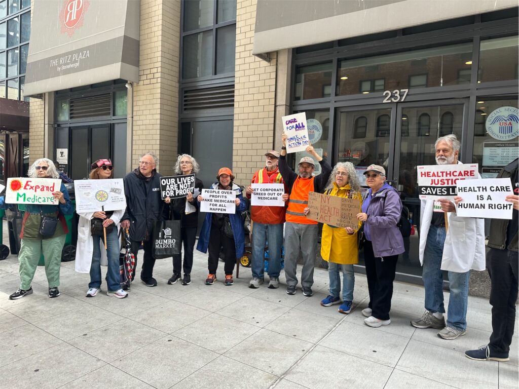 Radical Elders outside midtown Manhattan Social Security office with signs supporting Medicare expansion, healthcare justice, and health care as a human right