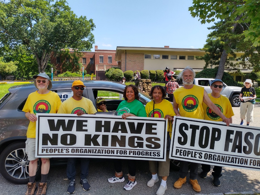 Members of POP gather for the Montclair parade holding signs reading “We have no kings” and “Stop fascism”.