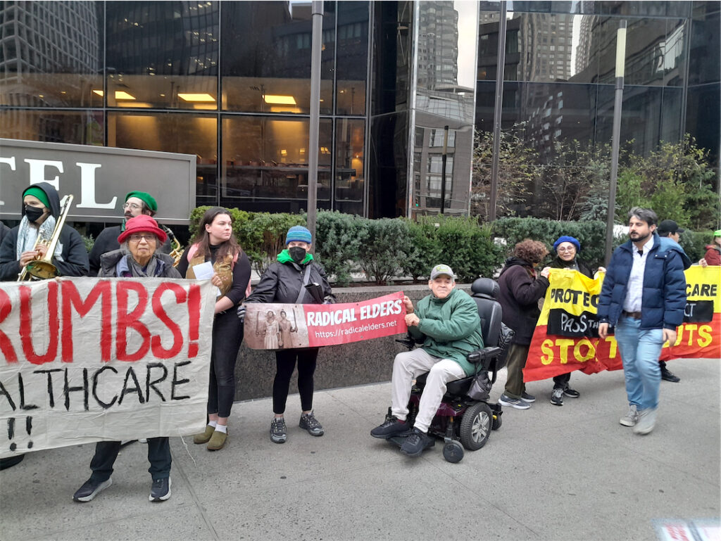 ralliers, including one man using a wheelchair, hold banners outside Trump Hotel as a man passes by