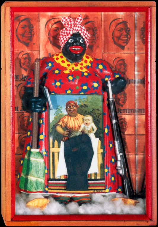 Saar's famed Aunt Jemina assemblage is laid inside of a shoebox-sized frame, plastered with Aunt Jemima advertisements. A caricatured sculpture of Aunt Jemima presents a notepad with a photograph of a Mammy with a white baby depicted. The Aunt Jemima sculpture holds a broom and a rifle, subverting her happy servant and caregiver stereotype by way of a militant alter ego who demands her own agency and power. A large, clenched fist, echoing the Black power symbol, is collaged over and partially obscuring the Mammy photograph, recognizing the aggressive and radical means used by African American activists in the 1970s to fight for their rights. Aunt Jemima is liberated through transformation from a racist domestic caricature into an image of Black power.
description from wikipedia, footnoted to “Farrington, Lisa E. (2005). Creating their own image : the history of African-American women artists. Oxford: Oxford University Press. pp. 162–167. ISBN 978-0195167214. OCLC 53144618”